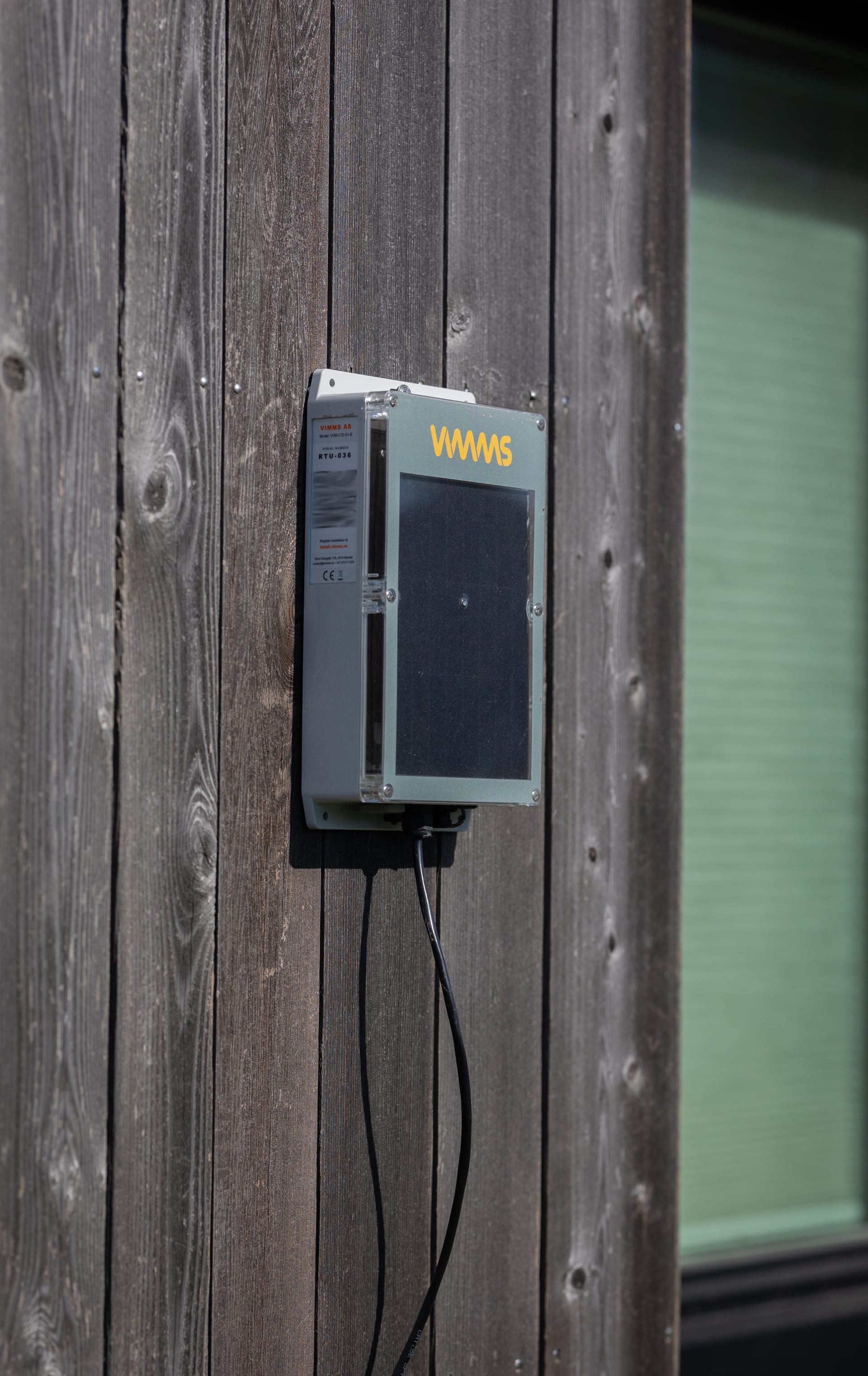 VIMMS Vibration Monitor mounted on wooden wall with solar panel